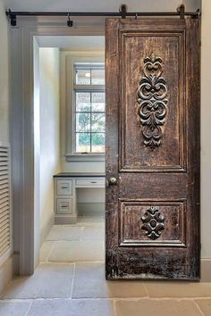 an old wooden door is open in the hallway