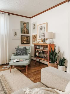 a living room filled with furniture and pictures on the wall