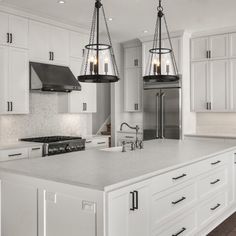 a large kitchen with white cabinets and an island