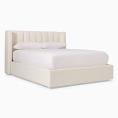 the bed is made up with white sheets and headboard, but no pillows on it