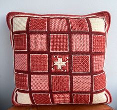 a red and white pillow sitting on top of a wooden table