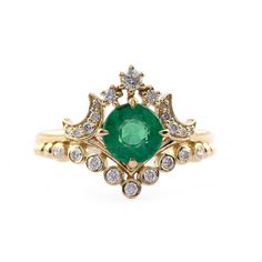 an emerald and diamond ring, with two diamonds on each side in gold plated setting