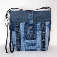 a purse made out of old jeans on a white background with a black and grey strap