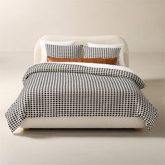 a bed with black and white checkered bedspread, pillows and pillow cases