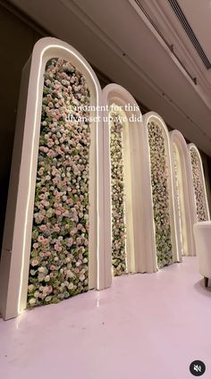 a room with white chairs and flowers on the wall