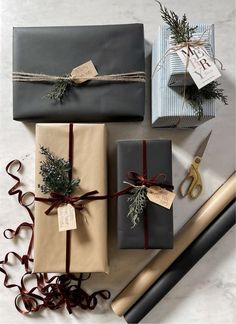 presents wrapped in brown paper and tied with twine on top of each other next to scissors