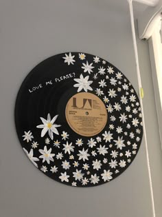 a record with flowers on it hanging from the wall next to a window in a room