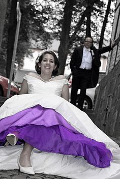 a woman in a purple and white dress sitting on the ground next to a man