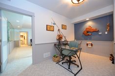 a room with a desk, chair and lamp on the wall next to an open door