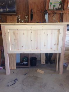 an unfinished bed frame in the middle of a room with wooden walls and flooring