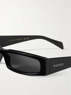 Gucci Eyewear's sunglasses have bold, futuristic wrap-around frames and tinted lenses to match the sturdy acetate. They're detailed with the brand name along the wide arms and come in a versatile black shade. Gucci Acetate Sunglasses With Tinted Lenses, Gucci Tinted Acetate Sunglasses, Modern Gucci Acetate Sunglasses, Modern Gucci Sunglasses In Acetate, Gucci Sleek Square Frame Sunglasses, Sleek Gucci Sunglasses With Tinted Lenses, Sleek Gucci Square Frame Sunglasses, Modern Gucci Shield Sunglasses With Tinted Lenses, Gucci Eyewear