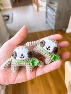 two small stuffed animals are held in someone's hand