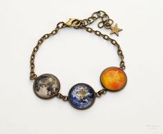 an image of three planets on a chain bracelet