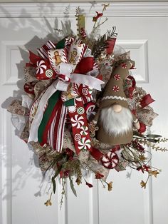 a christmas wreath with a gnome and candy canes hanging on the front door,