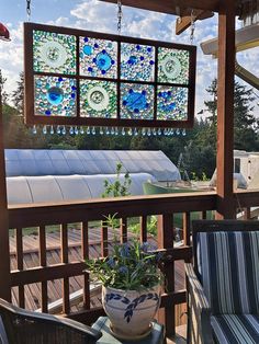 a potted plant sitting on top of a wooden table next to a window covered in blue and white tiles