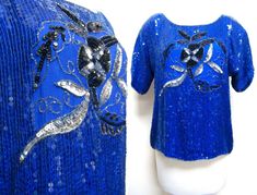 "Beautiful blue sequin top with black and gold detailing. Great for the holidays and New Year's Eve. Label: J.L.B. Materials: 100% Pure Silk Care: Dry Clean Size: Large Bust: up to 44\" Waist: 42\" Shoulder: 21\" Sleeve: 7\" Length: 22\" This garment is in excellent vintage condition." Fitted Sequin Tops For Christmas, Fitted Sequined Christmas Tops, Fitted Christmas Sequin Tops, Blue Embellished Party Blouse, Glamorous Blue Sequined Tops, Elegant Blue Sequined Tops, Festive Blue Sequined Tops, Festive Blue Sequin Tops, Festive Blue Sequined Blouse