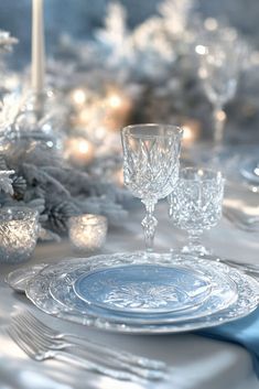 a table set for christmas dinner with silverware and candlesticks in the background