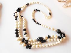 "A glamorous pearl and black bead necklace. Wow, this is a real statement necklace. The back of this glamorous necklace is a single strand of faux pearl and black beads. In the front it forms three strands. Both the pearl and black beads are in graduated sizes. It fastens with a tab insert closure. You will love this daytime to evening necklace. A lovely jewelry gift for her.. MATERIAL: Faux pearl and black beads CONDITION: It is in good condition SIZE: From back clasp to bottom of drop is 18\" Black Pearl Evening Necklace, Black Pearl Necklace For Party, Evening Necklace, Black Bead Necklace, Vintage Pearl, White Necklace, Wedding Jewellery Necklace, Vintage Pearls, Lovely Jewellery