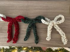 three crocheted bows are hanging from a christmas tree