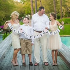 a family standing on a dock holding a banner