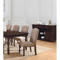 a dining room table and chairs in front of a white wall