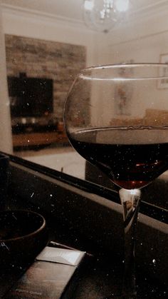 a glass of wine sitting on top of a counter