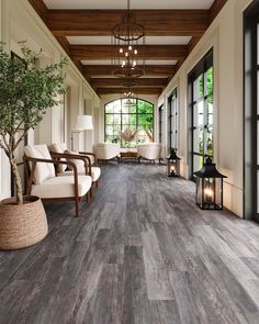 a large room with wood floors and white furniture in the center is lit by lanterns