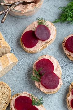 small sandwiches with beets and cream cheese are on a blue surface next to bread