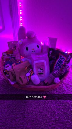 a pink basket filled with lots of toys and snacks on top of a purple carpet