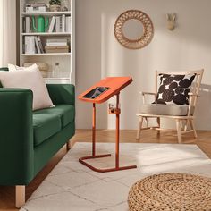 a living room with a green couch and a wooden table in front of a book shelf