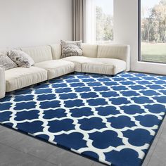 a living room with a large blue and white rug on the floor next to a couch