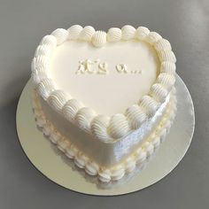 a white heart shaped cake on a plate