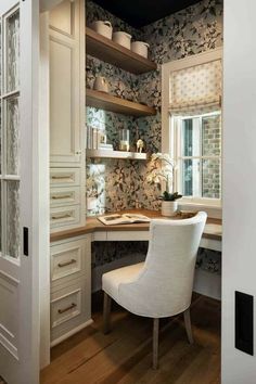 a home office with built - in desk and storage cabinets, along with white chairs