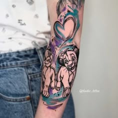 a woman's arm with a lion and heart tattoo on the left side of her arm