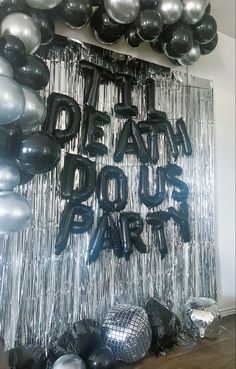 black and silver balloons are hanging on the wall