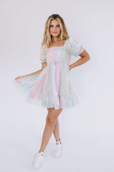 For the days you need more color, we've got you covered. Introducing the Head In The Clouds Dress to our Exclusive collection! A one-of-a-kind dress that is as fun, shimmery, + vibrant as you! Details Iridescent pastels Shimmery look Rainbow colored Lined Short puff sleeves Square neckline Elastic along shoulders Smocked back Tier hem Soft! Mini-length dress Sizing *Measurements are taken with item hanging and fabric unstretched.* Measurements for this style may seem small due to the elastic smo Tulle Outfit, Dress For A Party, Eras Tour Concert, Lover Era, Pastel Dress, Head In The Clouds, Birthday Party Outfits, Rainbow Dress, Easter Dress