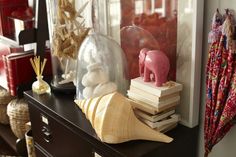 an elephant figurine sitting on top of a book shelf next to other items