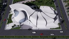 an aerial view of a large white building in the middle of a parking lot with lots of trees