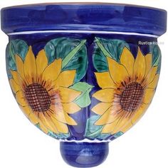 a blue vase with sunflowers painted on it