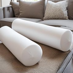 two large white pillows sitting on top of a couch