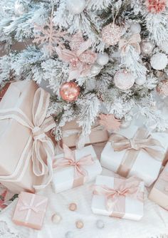 presents under the christmas tree with pink and white decorations