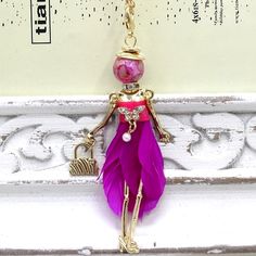 New Arrival Paris Handmade Lady Doll Charm Necklace With Long Gold Chain. See Last Pic For Measurements Of The Pendant & Chain. Necklace Is Long Enough To Pull Over Your Head. There's No Clasp For Adjustment But If You Need One To Make Shorter I'll Add 1 For No Extra Charge. The Pendant Doll Has A Bead Head, Movable Arms, Purse, Ribbon & Real Feather Made Dress, Etc. You Can See All These Details In The Pics. Spectacular Necklace! Charm Is Removable. Brand New & Packaged. Pink Long Necklace For Party, Long Pink Necklace For Parties, Cute Pink Necklace For The Beach, Pink Necklace With Lobster Clasp, Cute Pink Necklace For Beach, Cute Pink Necklaces For Beach, Pink Bohemian Chain Jewelry, Diy Crochet Jewelry, Bead Dolls