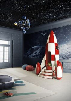 a room with a rocket ship painted on the wall and stars in the sky above it