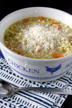 a bowl of chicken noodle soup with parmesan cheese