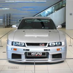 a silver sports car parked in front of an escalator