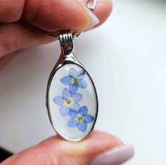 Bayou Glass Arts Stained Glass Pendant I have made glass pendants with forget me nots for years but never have I placed blooms in an oval shape. Oversight I guess as I think the cascade of blooms is both feminine and makes for a meaningful gift. Three forget-me-not blooms in quality glass. Forget Me Not Glass Pendant: 1 3/4 inch H x 3/4 inch W Choose Shiny Silver (shown) or Gunmetal (aged silver) Finish Select your length of fully adjustable figaro chain with secure lobster claw clasp Real dry p Art Stained, Tiffany Style, Shiny Silver, Heart Bracelet, Flower Jewellery, Heart Jewelry, Meaningful Gifts, Glass Pendants, Gemstone Jewelry