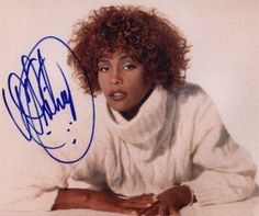 a woman with curly hair laying on the floor wearing a white shirt and scarf over her shoulders