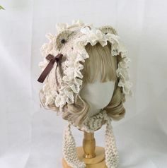 a mannequin head wearing a crocheted hat with flowers on it's side