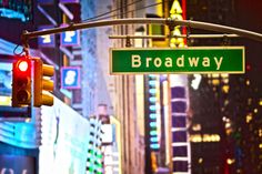 a green street sign hanging from the side of a traffic light