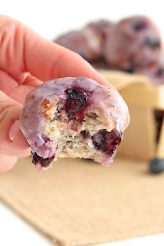 a hand holding a half eaten blueberry muffin